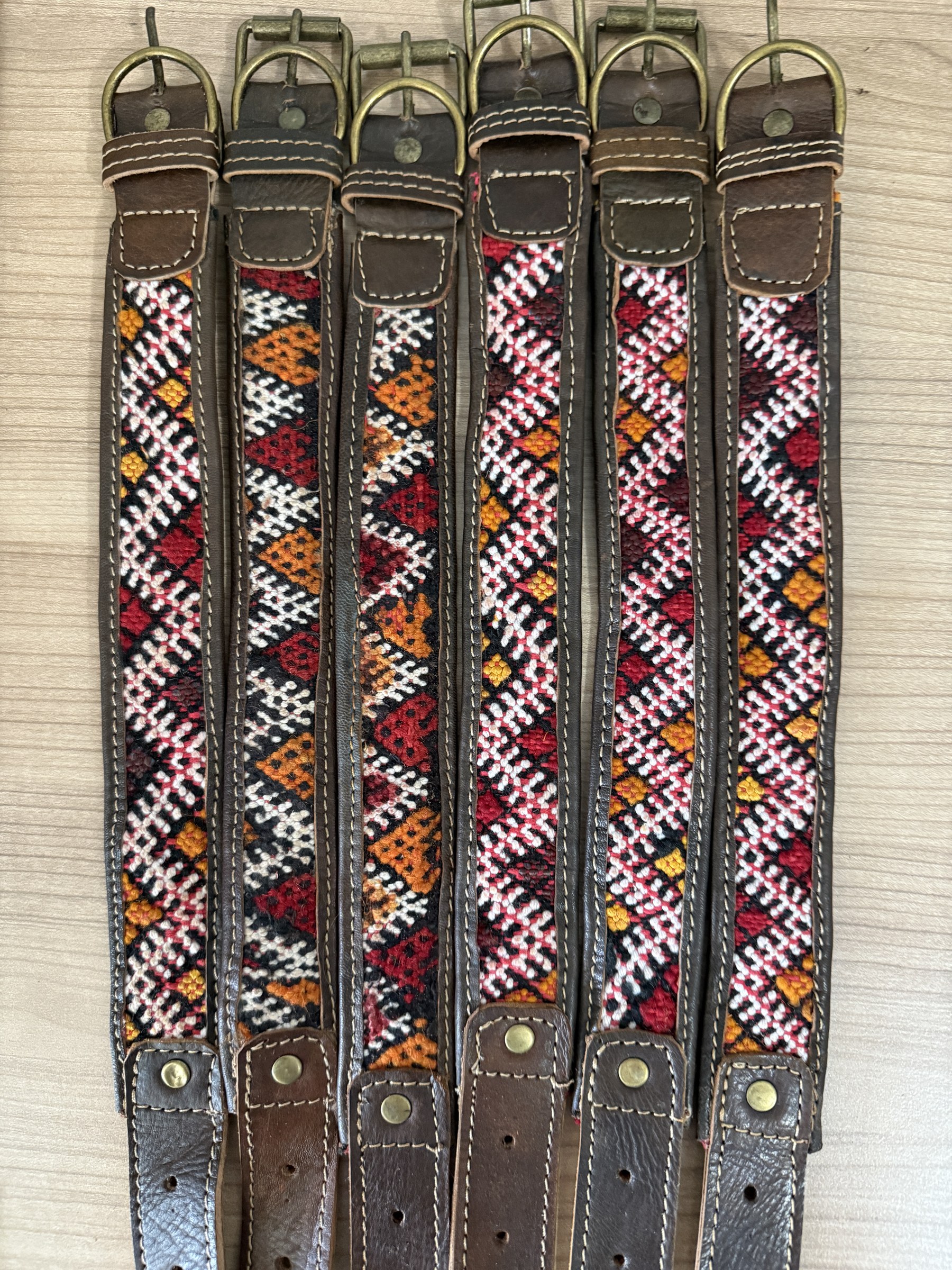 A row of assorted zigzag kilim collars laid side by side